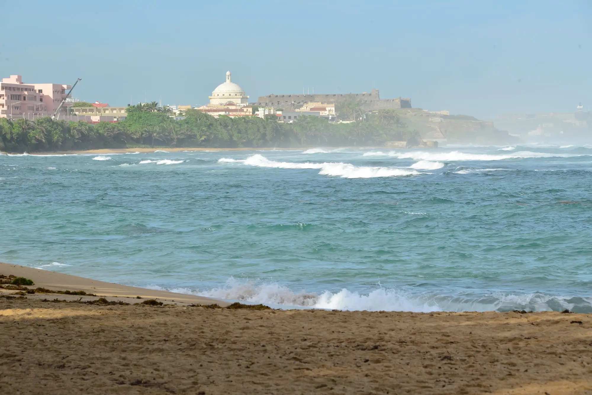 Waves on the sand at Puerta de Tierra, with the Capitol in the background