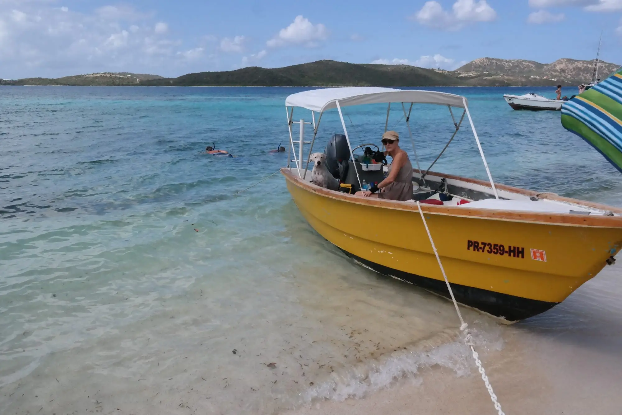 A water taxi pulled up on a beach in Culebrita, with snorkelers in the clear water